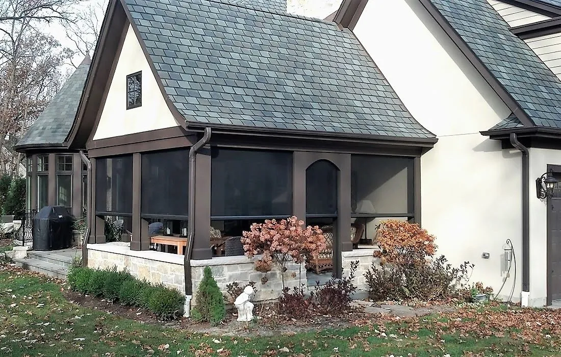Motorized privacy screens enclosing garage openings on a brick home
