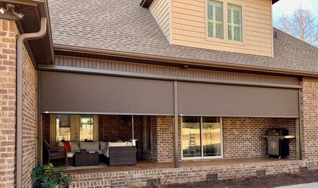 Finished motorized screen installation on a brick home porch